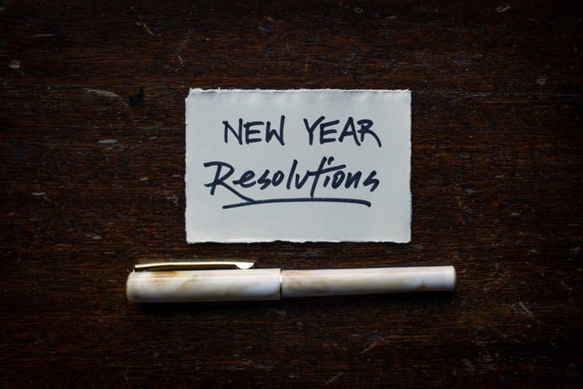 New Years Resolution written on paper, pen underneath