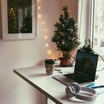 Mini christmas tree, standing desk, laptop and headphones