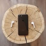 iPhone and airpods on wooden stump