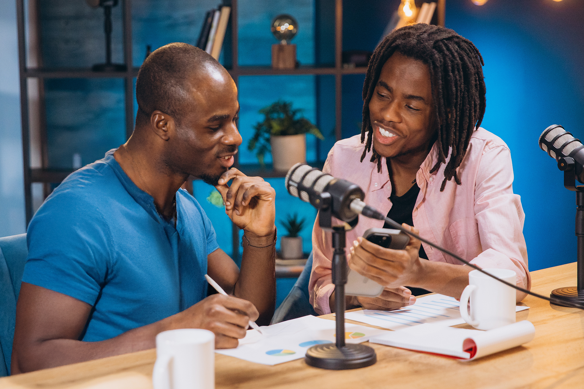 A podcaster showing the new website for their podcast show to his co-host.